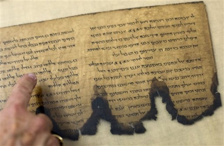 A staff member from the Israel Antiquities Authority points at a fragment of the Dead Sea Scrolls in a laboratory in Jerusalem on Tuesday.